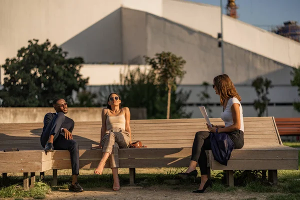 Τρεις Πολυφυλετικοί Επιχειρηματίες Απολαμβάνουν Τον Ήλιο Ενώ Κάθονται Στον Πάγκο — Φωτογραφία Αρχείου