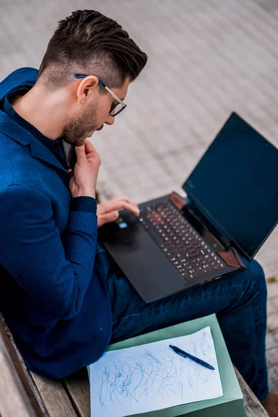 Urbaner Junger Mann Mit Laptop Während Auf Bank Sitzt Und — Stockfoto