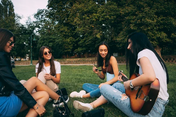 Dört Harika Güzel Kız Çimlerin Üzerinde Otururken Parkta Gitarın Tadını — Stok fotoğraf