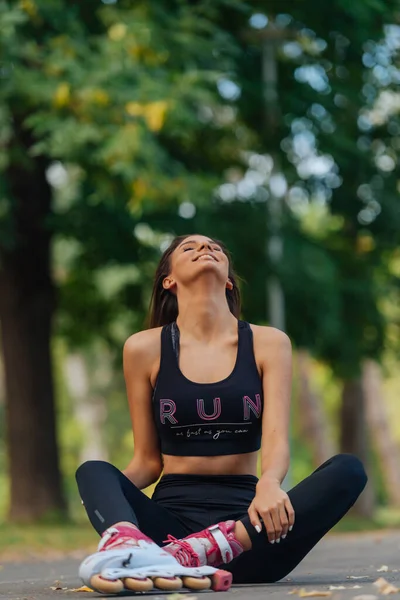 Spor Giyimli Yolda Oturan Patenlerle Poz Veren Beyaz Bir Kadının — Stok fotoğraf