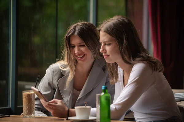 Дві Сестри Дивляться Телефону Коли Посміхаються Ресторані — стокове фото
