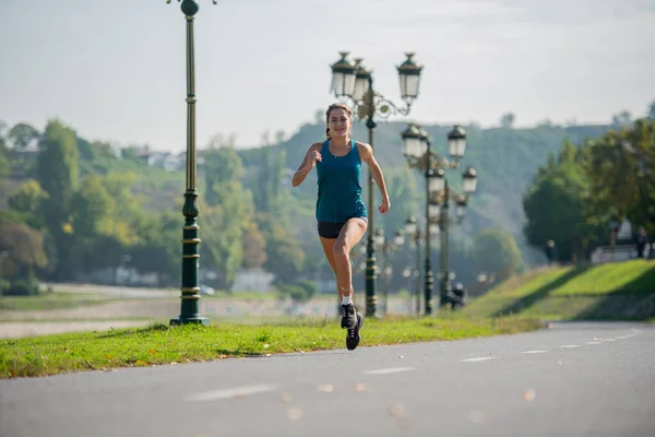 魅力的で美しいです女の子ありますランニングオンザトラック中ウォーミングアップ彼女の体 — ストック写真