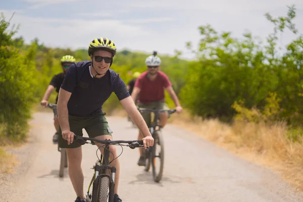 金发和健康的家伙骑着他的自行车 对着身后的法国佬笑着 — 图库照片