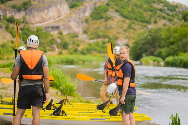 Portrait of blonde guy trying to help his friends with the kayak