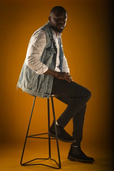 英俊而随意的黑人男子正站在高高的椅子上 — 图库照片