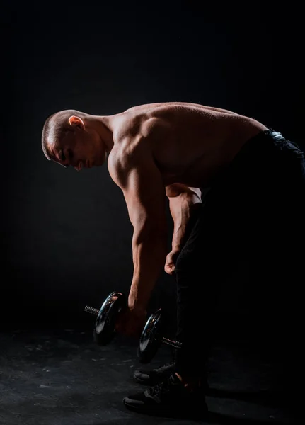 Jovem Com Haltere Prepare Para Flexionar Músculos Sobre Fundo Escuro — Fotografia de Stock