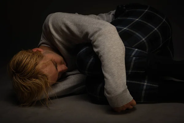 痛みを考えながら 落ち込んでいる少年が地面に横たわっている — ストック写真