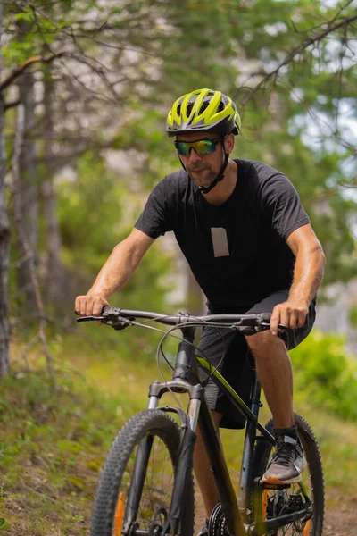 在森林里骑自行车的体育健将的画像 — 图库照片