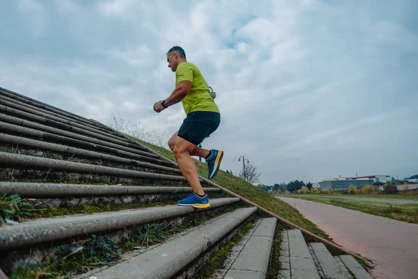走行中の階段運動中にスポーツ服を着た筋肉の男 — ストック写真