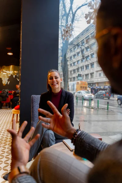 Dwóch Wielorasowych Partnerów Biznesowych Śmieje Się Rozmawia Siedząc Kawiarni — Zdjęcie stockowe