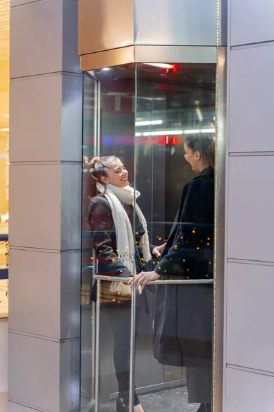 매력적 아름다운 사업가가 엘리베이터를 올라가면서 얘기하고 있습니다 — 스톡 사진