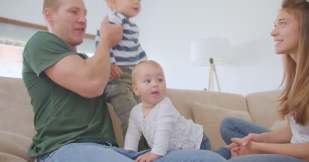 小さな子供は父親の首に座っている小さな赤ちゃんは楽しいに参加しながら — ストック動画