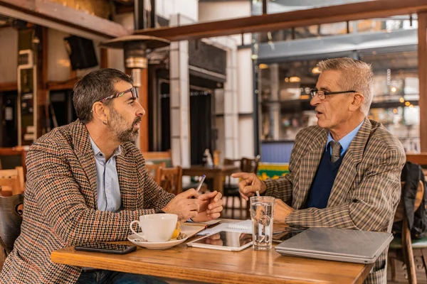 Δύο Ανώτεροι Επιχειρηματίες Συζητούν Σοβαρά Για Συνάντησή Τους Στο Καφέ — Φωτογραφία Αρχείου