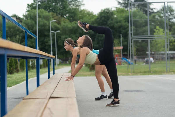 Two Girls Stretching While One Them Lifting Her Leg Her — Stock Photo, Image
