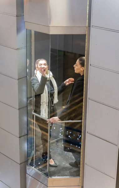 매력적 아름다운 사업가가 엘리베이터 안에서 뭔가를보면서 대화를 나누고 있습니다 — 스톡 사진