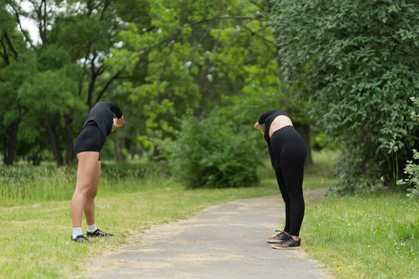 Twee Aantrekkelijke Meisjes Strekken Hun Rug Uit Voor Training — Stockfoto