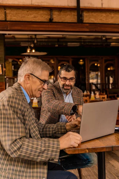 Zwei Hochrangige Geschäftsleute Blicken Auf Den Laptop Und Lächeln — Stockfoto