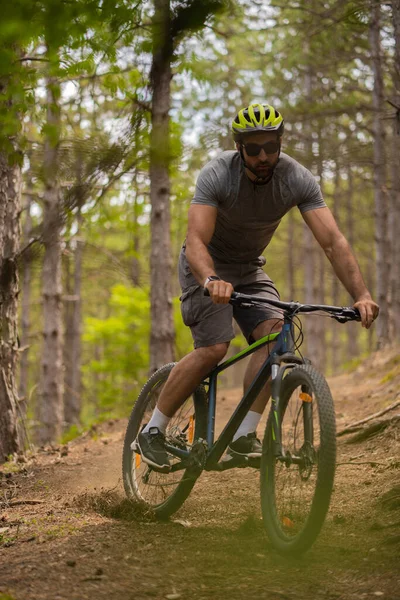 英俊健康的男人骑着他的自行车在森林里漂泊 — 图库照片