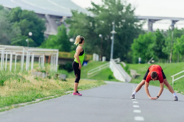 Casal Jovem Aquecendo Alongando Juntos Parque Antes Correr — Fotografia de Stock