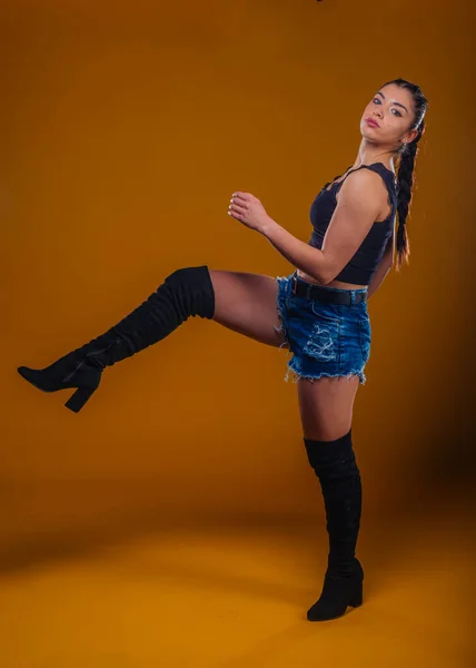 Mladá Sexy Žena Pózuje Studiu Nohou Vzduchu Izolované Přes Žlutooranžové — Stock fotografie