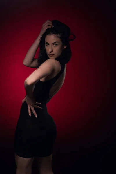 Chica Seductora Atractiva Está Posando Desde Espalda Sobre Fondo Rojo —  Fotos de Stock