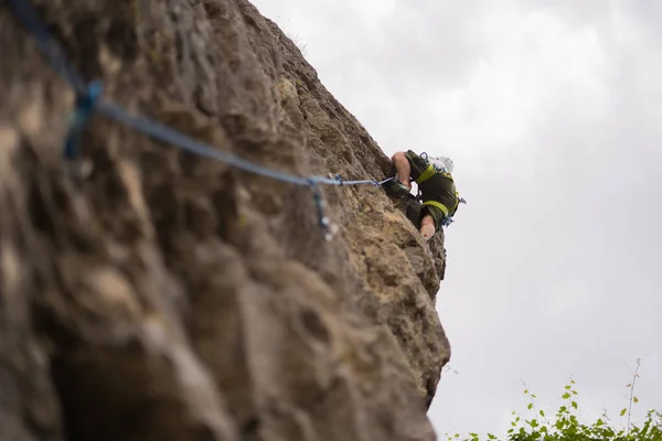Yakışıklı Genç Adam Yüksek Tepeye Tırmanıyor Zirveye Ulaşmaya Çalışıyor — Stok fotoğraf
