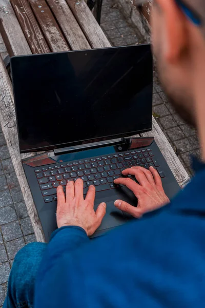 Bonito Jovem Usando Laptop Enquanto Sentado Banco Centro Cidade — Fotografia de Stock