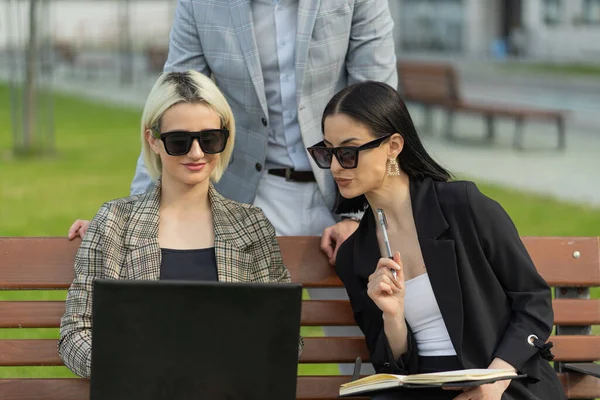 Three casual dressed business people are looking at the new plans they made so far