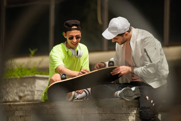 Dos Mejores Amigos Masculinos Están Mirando Patín Mientras Sonríen — Foto de Stock