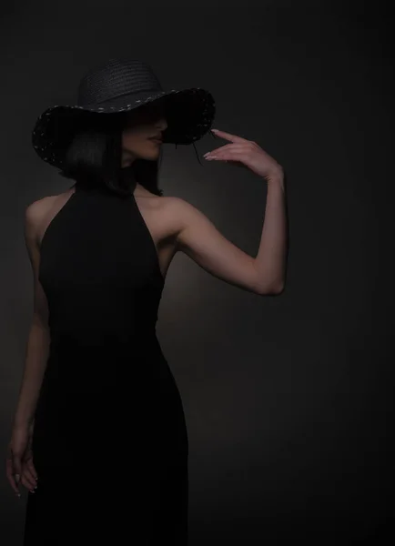 演播室里穿着黑色衣服 头戴黑色帽子的优雅女人的性感画像 — 图库照片