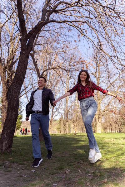 Cute couple walking and laughing in the park near the tree