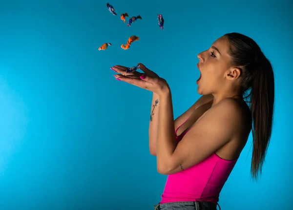 Nettes Mädchen Wirft Bonbons Studio Vor Blauem Hintergrund — Stockfoto