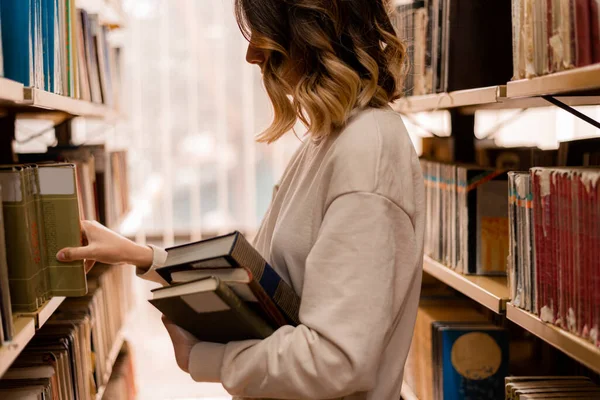 College Mädchen Wählt Ein Buch Aus Dem Bücherregal Der Bibliothek — Stockfoto