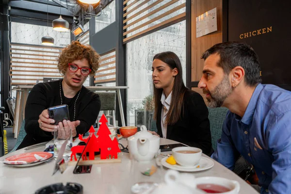 Three amazing business people are looking at the phone