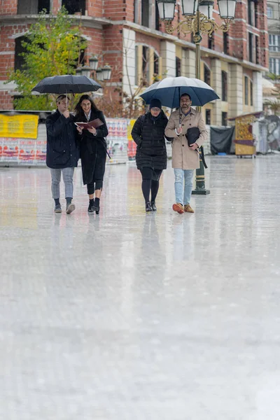 Four amazing and beautiful business people are walking on the rain together