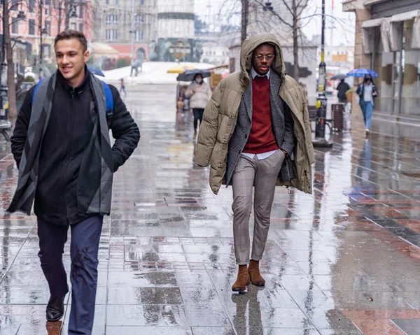 Two handsome and attractive business men are walking on the rain