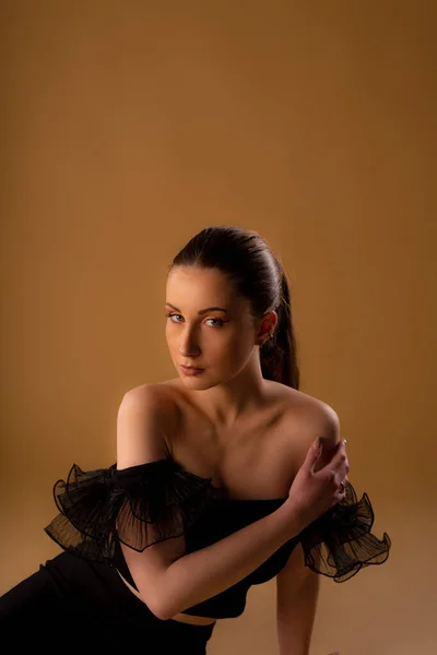 Portret Pięknej Modelki Pozującej Studiu Siedzącej Dotykającej Jej Ramienia — Zdjęcie stockowe