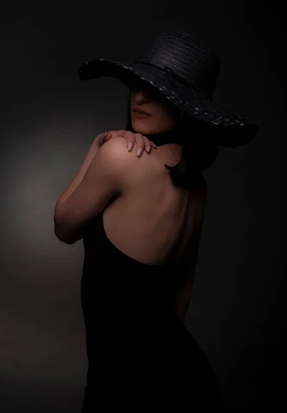 美しいです女の子ドレスで黒と帽子ありますポーズでスタジオ — ストック写真