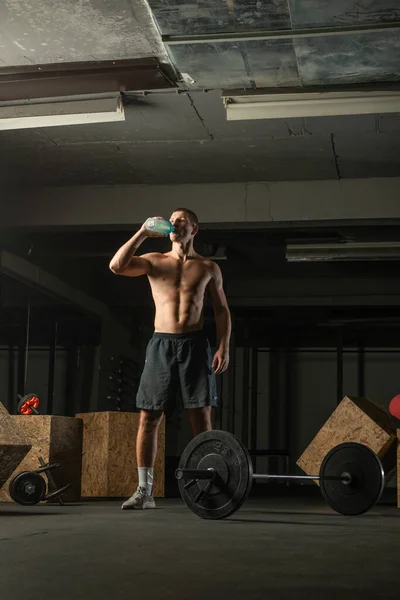 在喝水的时候 肌肉男从硬核运动中休息一下 — 图库照片