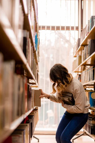 Mädchen Holt Ein Buch Aus Dem Bücherregal Der Bibliothek — Stockfoto