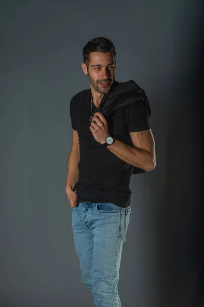 Silný Svalnatý Mužský Model Džínách Černým Tričkem Který Drží Bundu — Stock fotografie