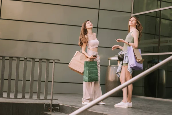 2人の美しい女の子とともに彼らのショッピングバッグ立って外をモール — ストック写真
