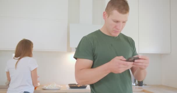 Matka Prostírá Stůl Zatímco Její Manžel Kontroluje Telefon — Stock video