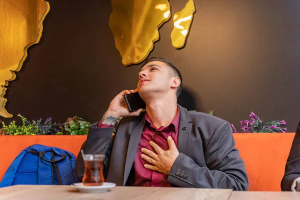 魅力的でハンサムなビジネスマンは彼の助けを借りて彼の電話で話している — ストック写真