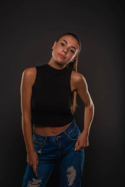 Attractive Beautiful Young Girl Posing Studio While Holding Her Jeans — Stockfoto