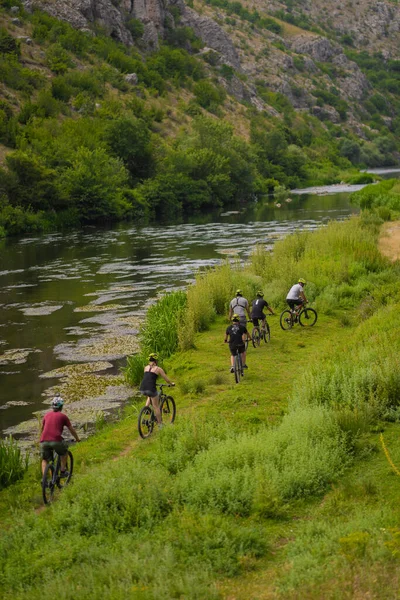 Happy people are riding their bikes together as a group while enjoying the nature around them