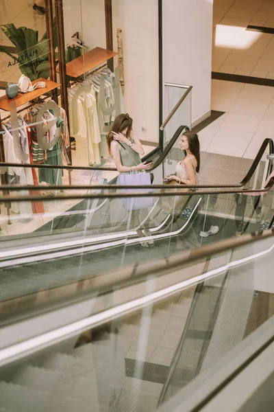Duas Meninas Bonitas Com Sacos Compras Subindo Escada Rolante — Fotografia de Stock