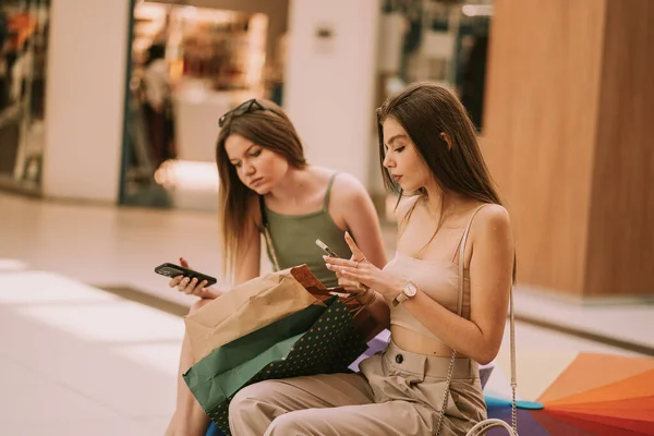 Close Cute Shopping Girls Sitting Sofa Mall While Looking Phones — 图库照片