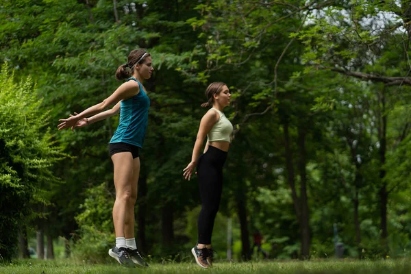 Two Attractive Well Build Girls Jumping Together While Training — Stock Fotó