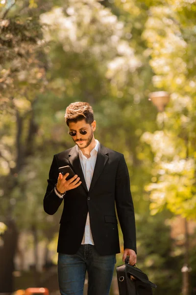 Geschäftsmann Schaut Beim Spaziergang Park Auf Sein Handy — Stockfoto